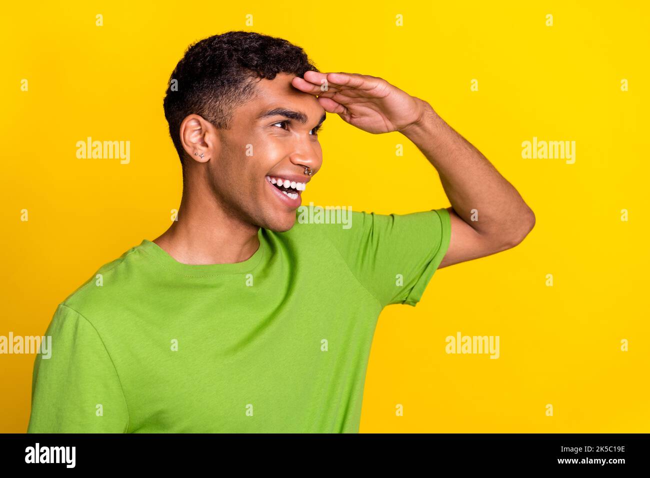 Profil photo de jeune sourire positif beau gars gai regardant loin de nouvelles aventures amis isolés sur fond jaune couleur Banque D'Images