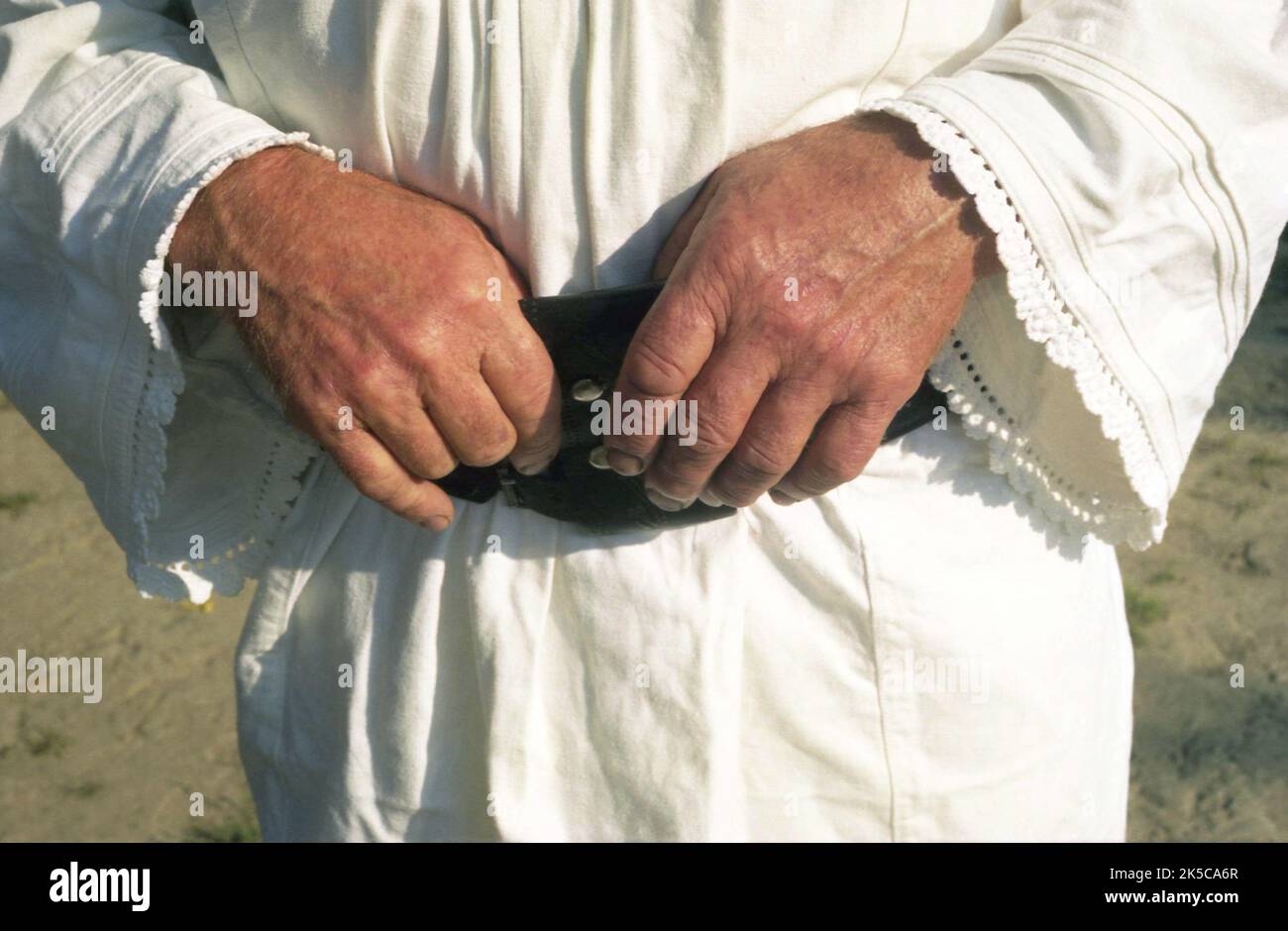 Comté de Bistrița-Năsăud, Roumanie, 2000. Homme de campagne portant un chemisier traditionnel et une ceinture en cuir. Gros plan de ses mains. Banque D'Images