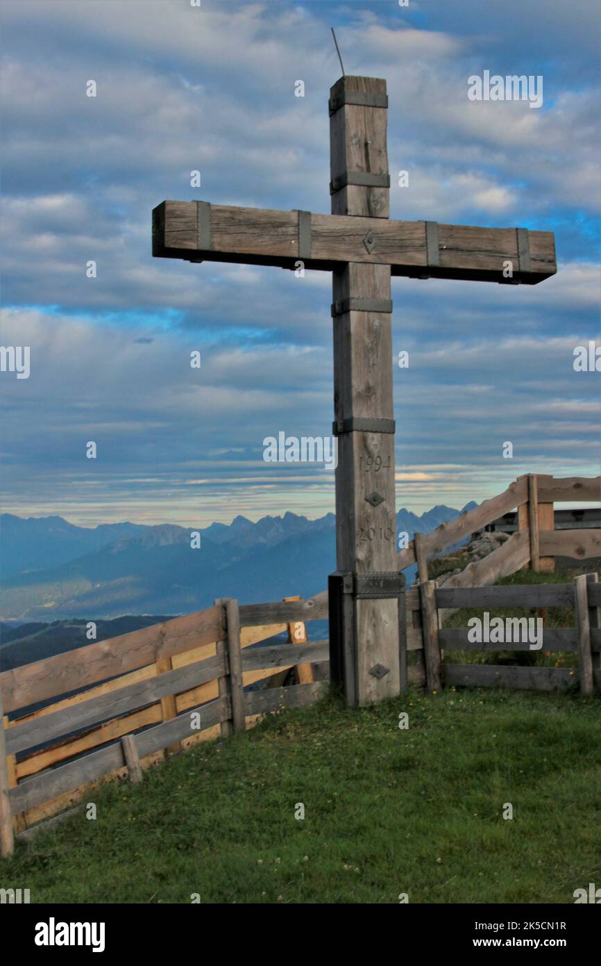 Croix devant Rotmoosalm, alp, ciel menaçant, clôture, coucher de soleil, Mont Wetterstein, Gaistal, Leutasch, Tyrol, Autriche Banque D'Images