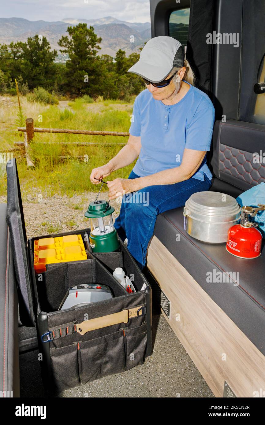 Femme stockant l'équipement de camping dans la boîte d'engrenages Radius Outfitters 500 Banque D'Images