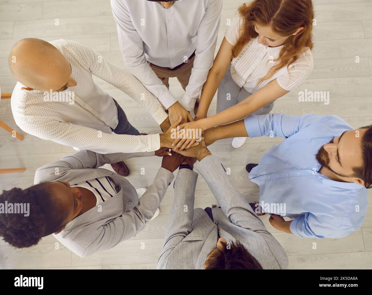 Vue de dessus d'une équipe de professionnels multiraciaux heureux qui se rassemblent Banque D'Images