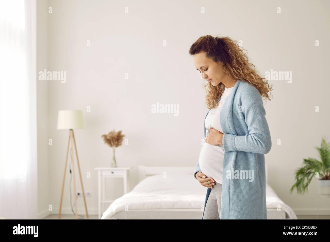 Une jeune femme en bonne santé touche le ventre de la grossesse Banque D'Images