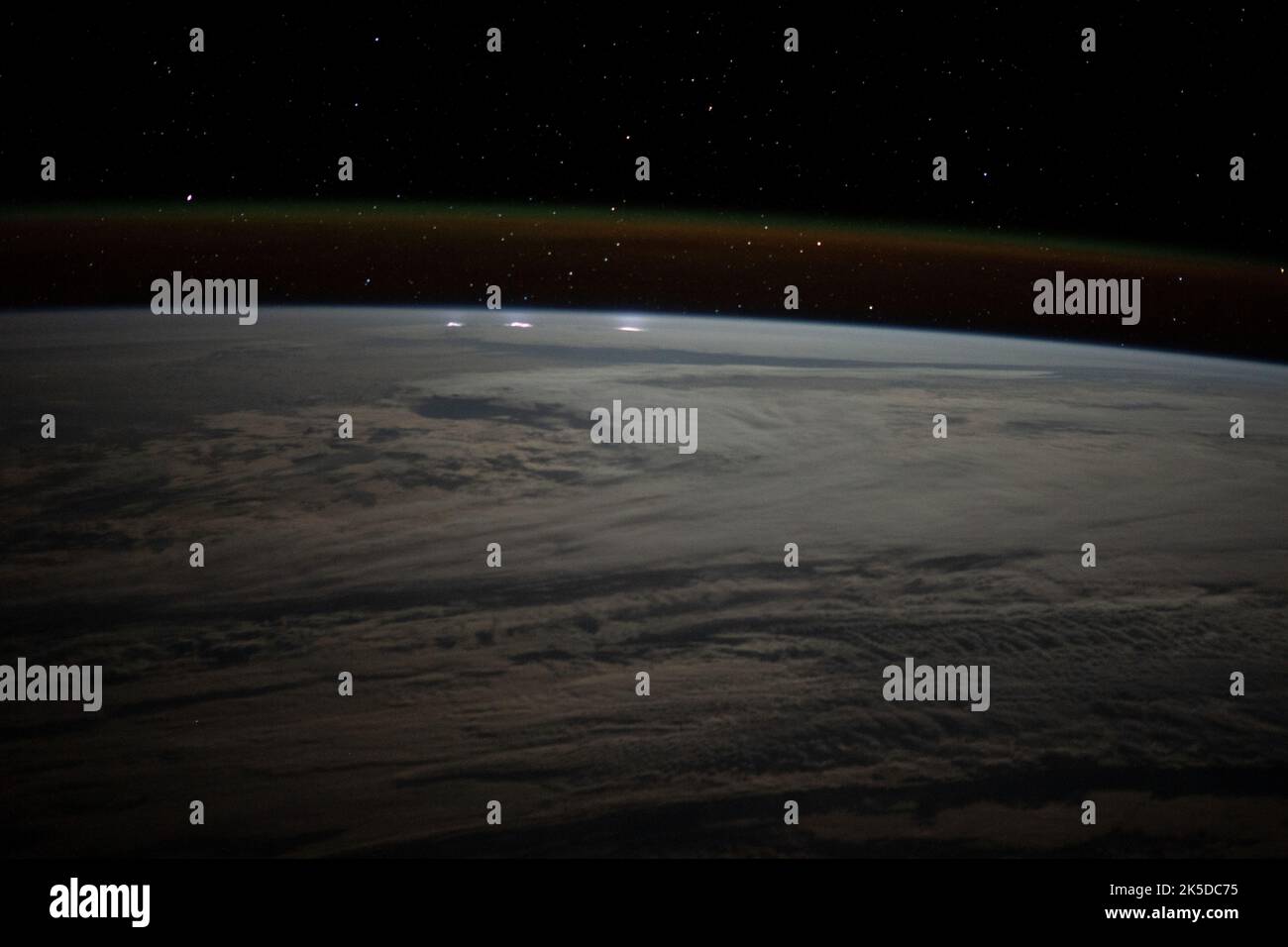 Un océan Indien du sud nuageux entre l'Afrique et l'Antarctique, avec des tempêtes de foudre près de l'horizon sous la lueur atmosphérique, est photographié de la Station spatiale internationale alors qu'elle était en orbite à 271 miles au-dessus Banque D'Images