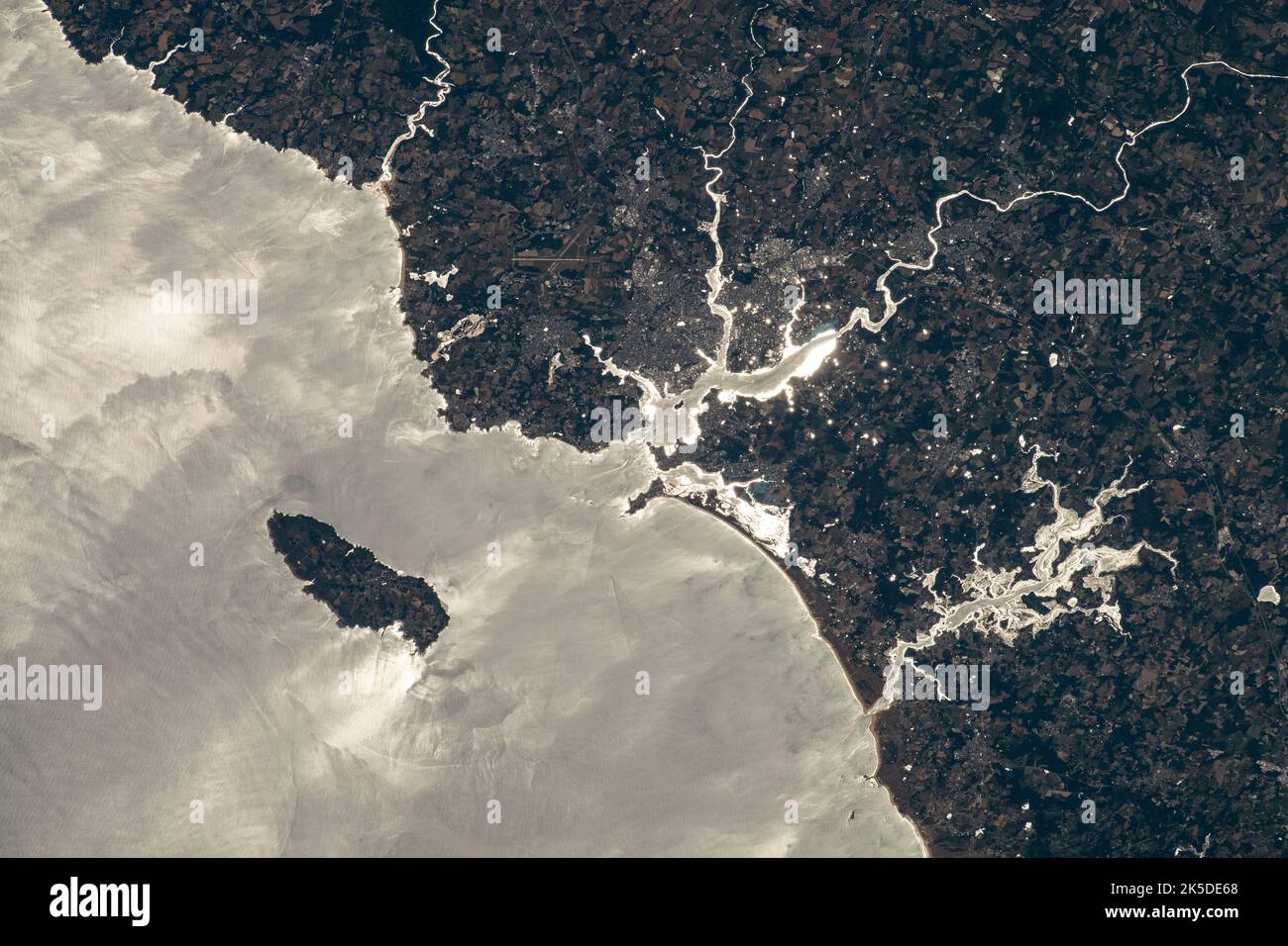 L'île de Groix est photographiée au large de la côte nord-ouest de la France, l'océan Atlantique baignant de la charpie du soleil dans cette photo de la Station spatiale internationale alors qu'elle était en orbite à 264 kilomètres au-dessus de la Manche. Les rivières (du haut à gauche au bas à droite) la Laïta, Blavet et Scorf, y compris la rivière d'Étel, se vident dans l'Atlantique. Banque D'Images