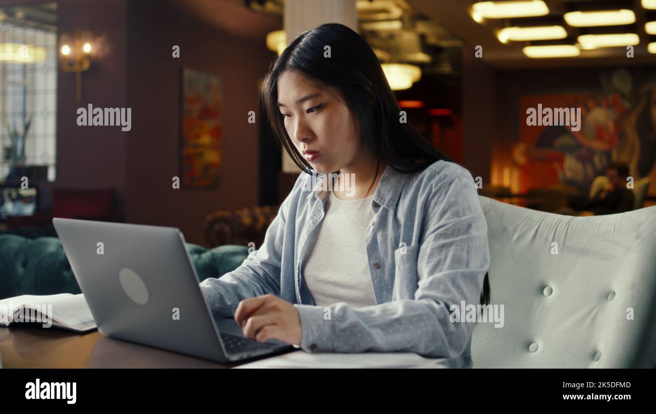 Femme d'affaires asiatique utilisant un ordinateur portable, travaillant en ligne sur le projet de démarrage, stratégie d'affaires, l'analyse de documents et de documents dans le café de bureau. Travailleur de la société de marketing de commerce électronique Banque D'Images