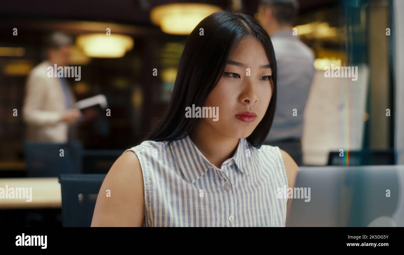 Femme d'affaires tapant sur un ordinateur portable. Femme asiatique travaillant sur le projet de démarrage, la stratégie d'affaires, la conception de site Web dans le bureau moderne près de collègues. Société de commerce électronique Banque D'Images