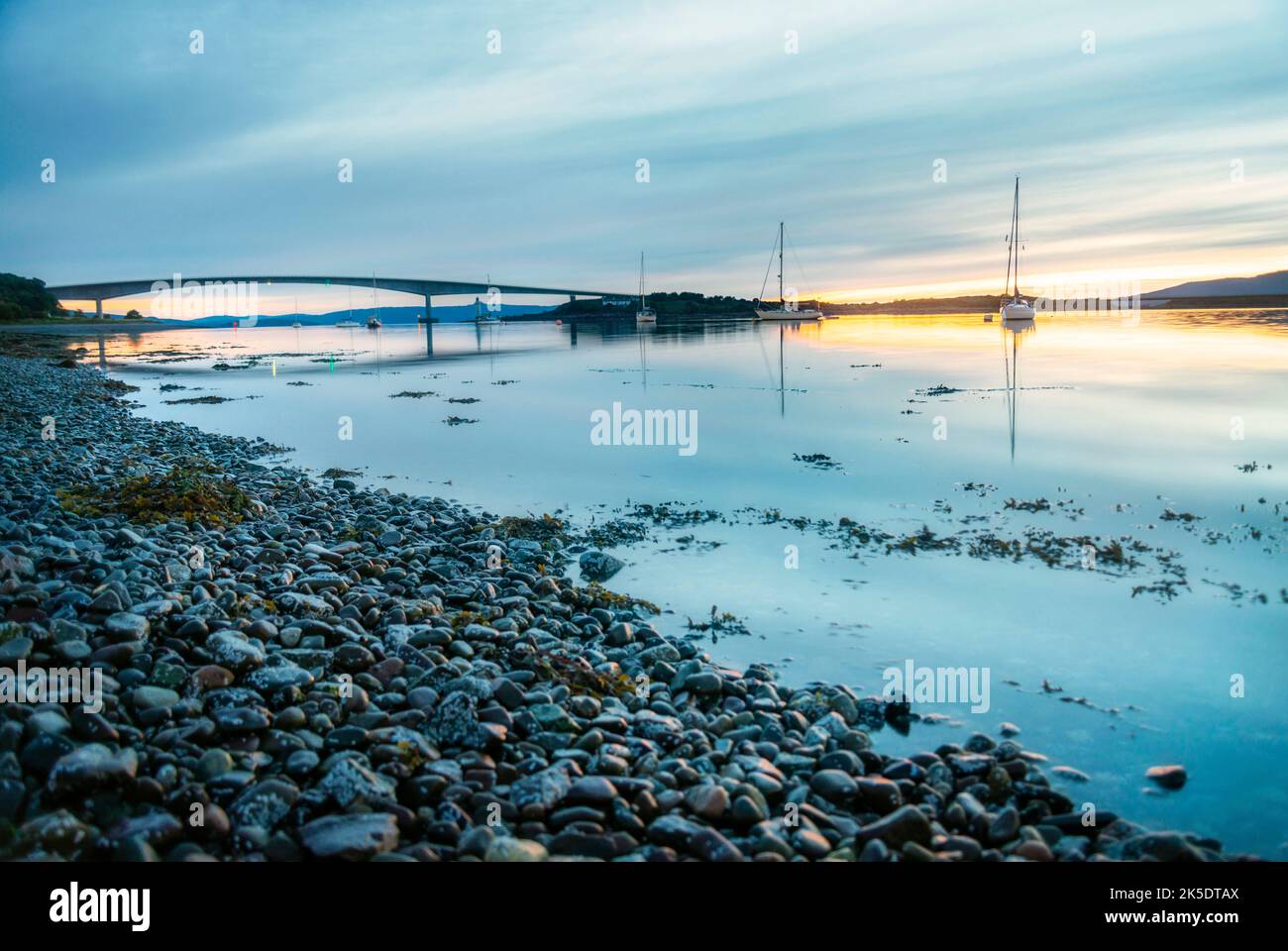 Ouvert en 1995, le pont routier reliant l'île de Skye à l'île d'Eilean Bàn et le continent écossais. Le soleil se couche à proximité de minuit dedans Banque D'Images