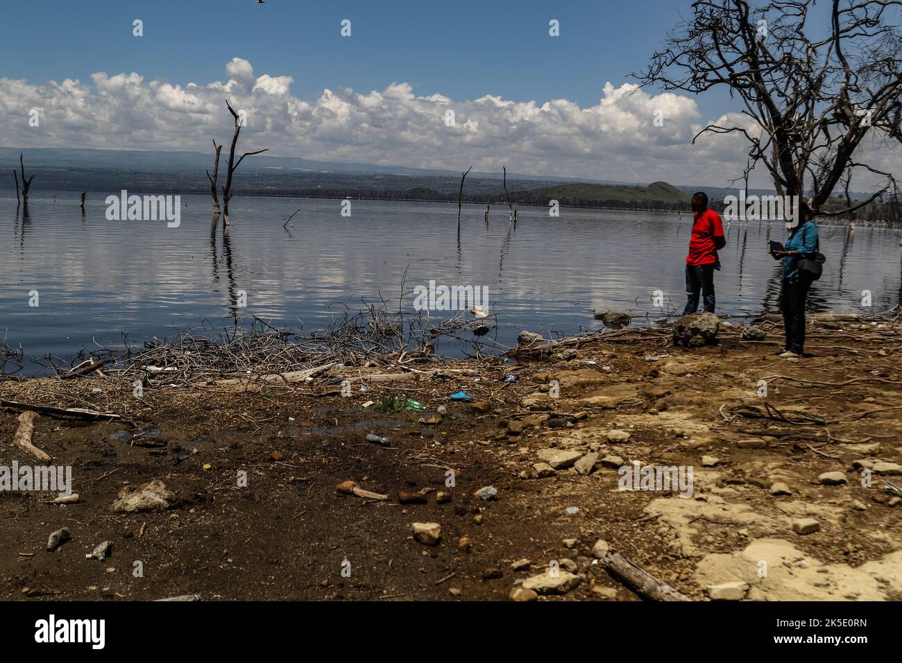 Un membre de la presse (L) et un scientifique se tiennent sur les rives du lac Nakuru lors d'un événement sur le terrain. Media for Science Health and Agriculture (MESHA), une organisation kenyane de médias, a organisé une mission d'enquête pour que les journalistes comprennent de première main l'impact du changement climatique sur la biodiversité dans le parc national du lac Nakuru. Banque D'Images