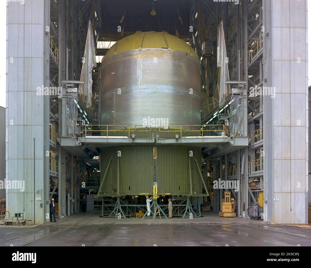 Le réservoir de carburant de l'étape S-IC-T de Saturn V (article d'essai statique S-IC) a été fixé à la structure de poussée dans le bâtiment d'assemblage de véhicules du Centre de vol spatial Marshall de la NASA. L'étape S-IC, première étape de la fusée Saturn V, utilisait cinq moteurs F-1 qui utilisaient de l'oxygène liquide et du kérosène comme gaz propulseur et qui fournissaient une poussée combinée de 7 500 000 livres. Une image optimisée de la NASA : Credit: NASA Banque D'Images