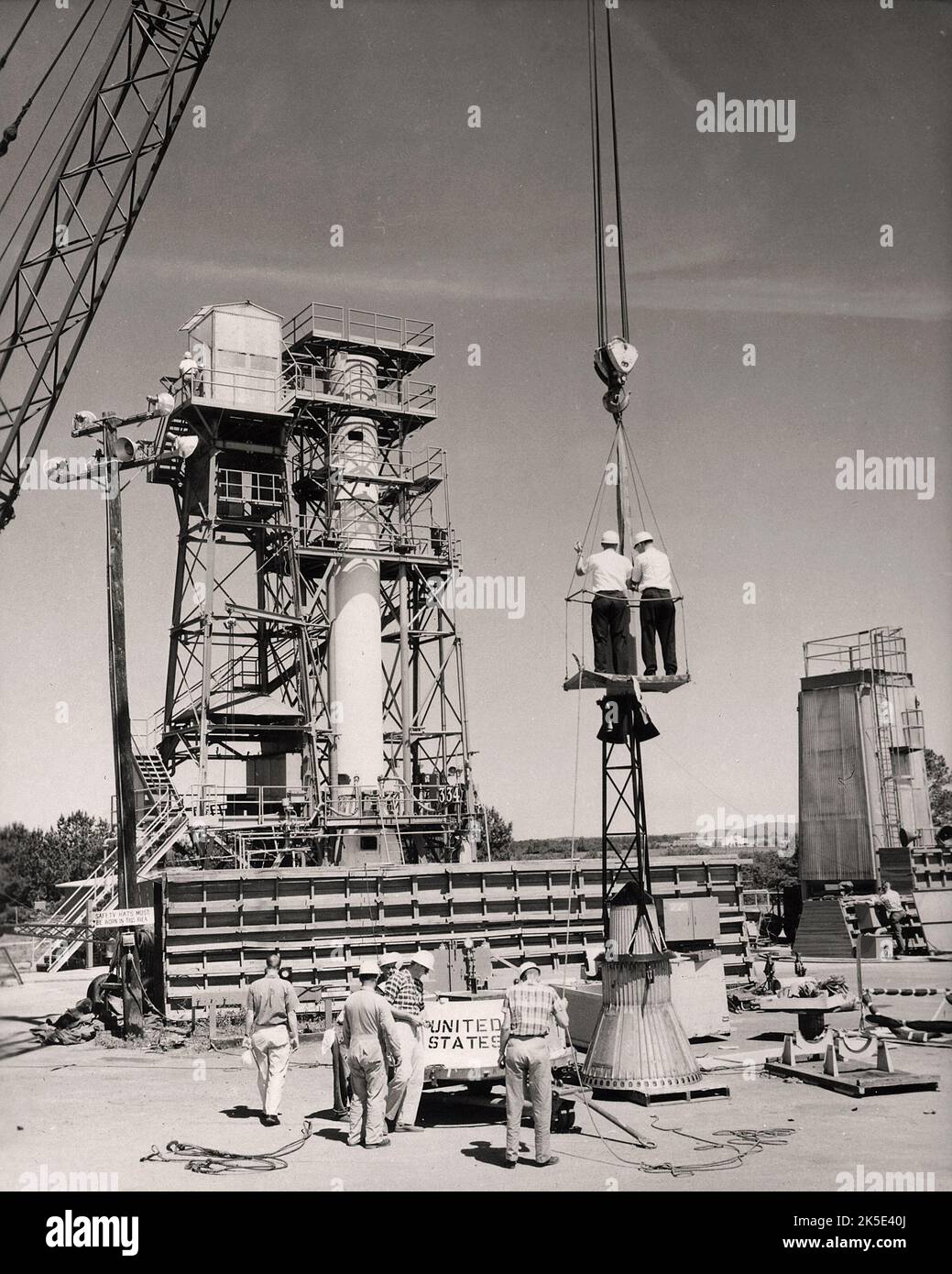 Cette photographie historique montre l'installation d'une capsule de mercure et d'un système d'évacuation sur le dessus du booster avant le tir d'essai de Mercury-Redstone au stand d'essai de Redstone au Centre de vol spatial Marshall (MSFC). 1960. Assemblé par MSFC, Mercury-Redstone a été conçu pour placer une capsule spatiale habitée en vol orbital autour de la terre et récupérer les deux en toute sécurité. Le MSFC, situé à Redstone Arsenal, en Alabama, est le centre de recherche sur la propulsion des engins spatiaux et le rocketry civils du gouvernement des États-Unis. Une version optimisée d'une image d'origine de la NASA. Crédit: NASA Banque D'Images