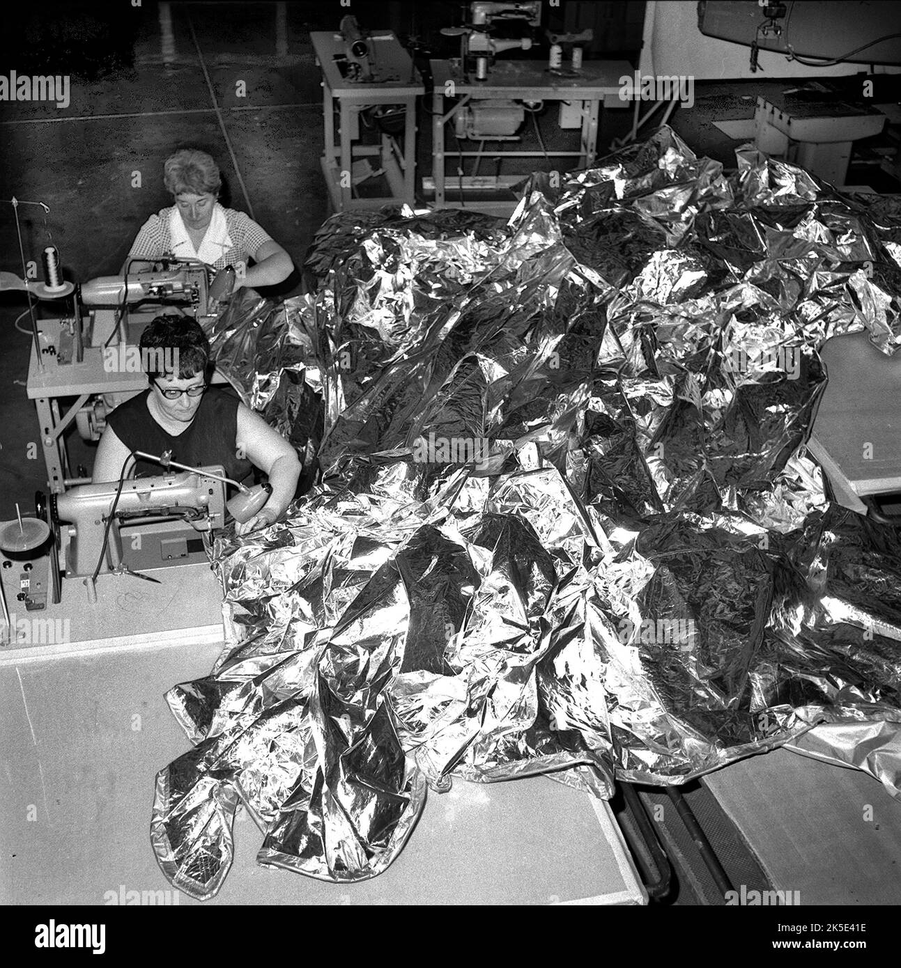 En mai 1973, Charles Conrad Jr., Paul Weitz et Joseph Kerwin ont lancé la première station spatiale américaine, Skylab. A l'arrivée, l'équipage a installé le parasol - vu ici cousu ensemble par deux couturières - et a libéré l'aile du panneau solaire. Sans le pare-soleil, la température à l'intérieur de l'atelier orbital de Skylab est devenue dangereusement élevée, ce qui a rendu l'atelier inhabitable les ingénieurs et les scientifiques du centre de vol spatial Marshall de la NASA ont travaillé à l'élaboration d'une procédure de réparation d'urgence. Une version optimisée d'une image d'origine de la NASA. Crédit: NASA Banque D'Images
