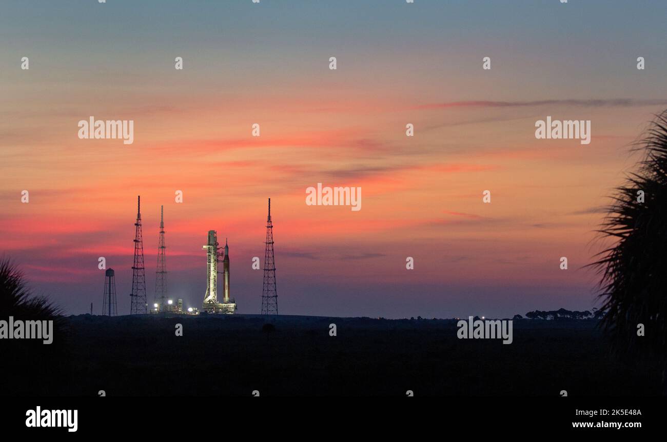 La fusée SLS (Space Launch System) de la NASA à bord de l'engin spatial Orion est vue au lever du soleil au sommet du lanceur mobile lorsqu'elle arrive au Launch Pad 39B, le 17 août 2022, au Kennedy Space Center de la NASA en Floride. L'essai en vol Artemis I de la NASA - le premier essai intégré des systèmes d'exploration spatiale profonde de l'agence : l'engin spatial Orion, la fusée SLS et les systèmes de soutien au sol. Le lancement de l'essai en vol sans équipage a été reporté. Une version optimisée d'une image d'origine de la NASA. Crédit: NASA/JKowsky) Banque D'Images