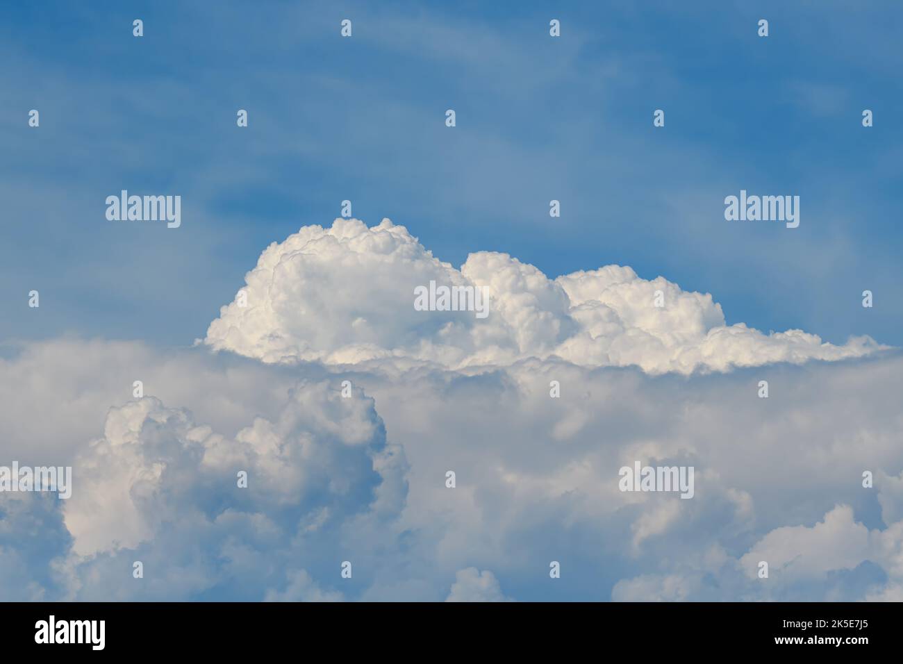 Un grand nuage blanc moelleux sous un ciel bleu lors d'une journée ensoleillée. Banque D'Images