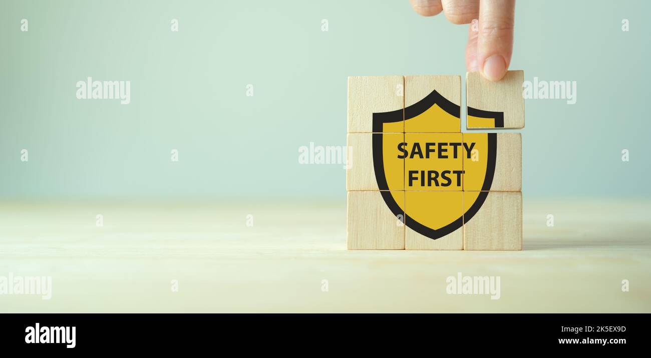 Symboles de sécurité d'abord, sécurité au travail, attention risques au travail, surveillance des dangers, concept zéro accident. Cubes en bois avec fond gris élégant. Employé Banque D'Images