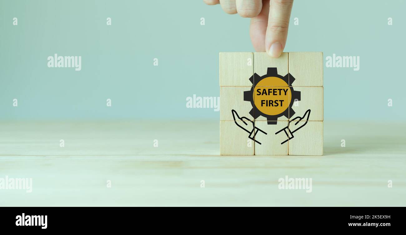 Symboles de sécurité d'abord, sécurité au travail, attention risques au travail, surveillance des dangers, concept zéro accident. Cubes en bois avec fond gris élégant. Employé Banque D'Images