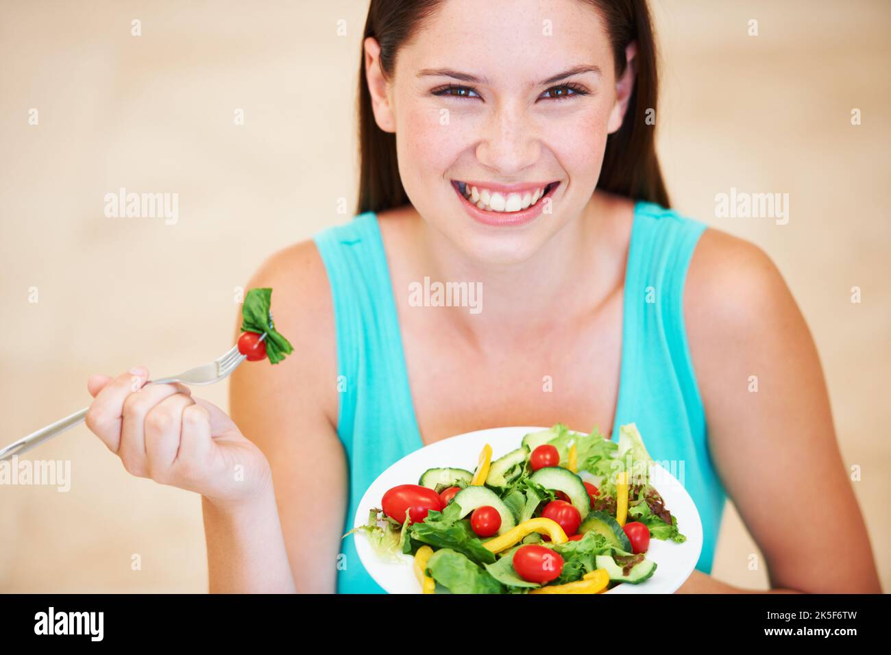 Elle aime ses verts. Portrait d'une jeune femme attrayante appréciant une salade. Banque D'Images