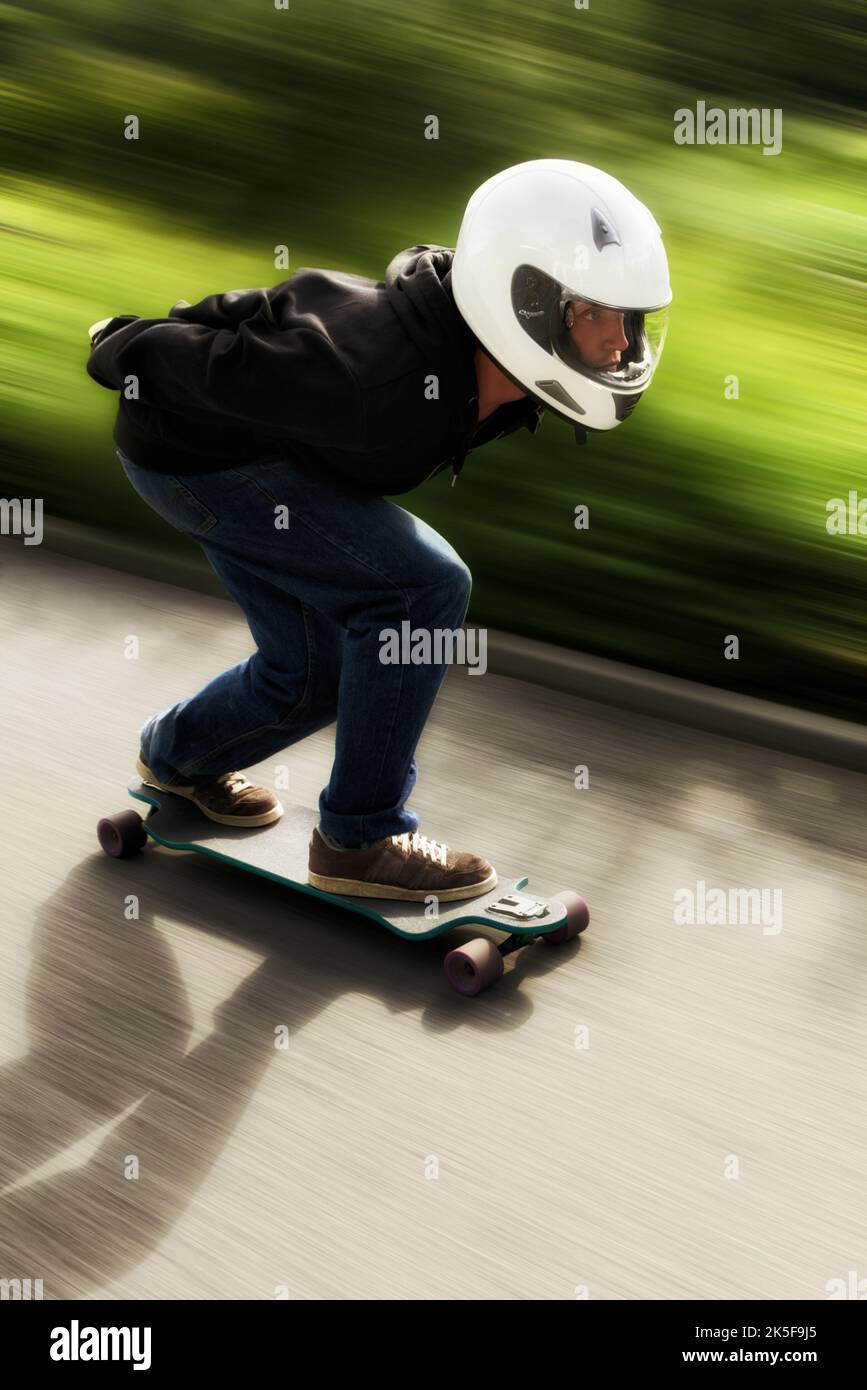 Un homme qui fait du skateboard à grande vitesse sur son plateau. Banque D'Images