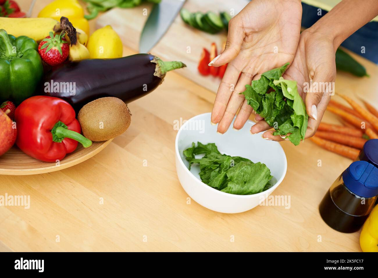 Préparer une friandise fraîche. Une femme prépare une salade dans sa cuisine. Banque D'Images