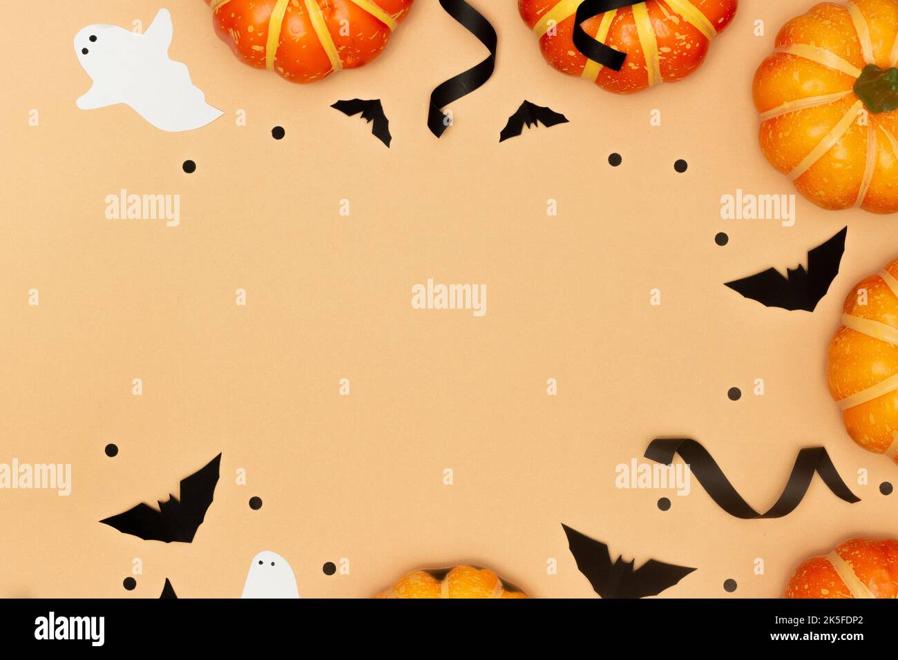 Concept de symbole Halloween, citrouilles à sourire effrayant et fantôme avec chauve-souris noire sur fond crème. Banque D'Images