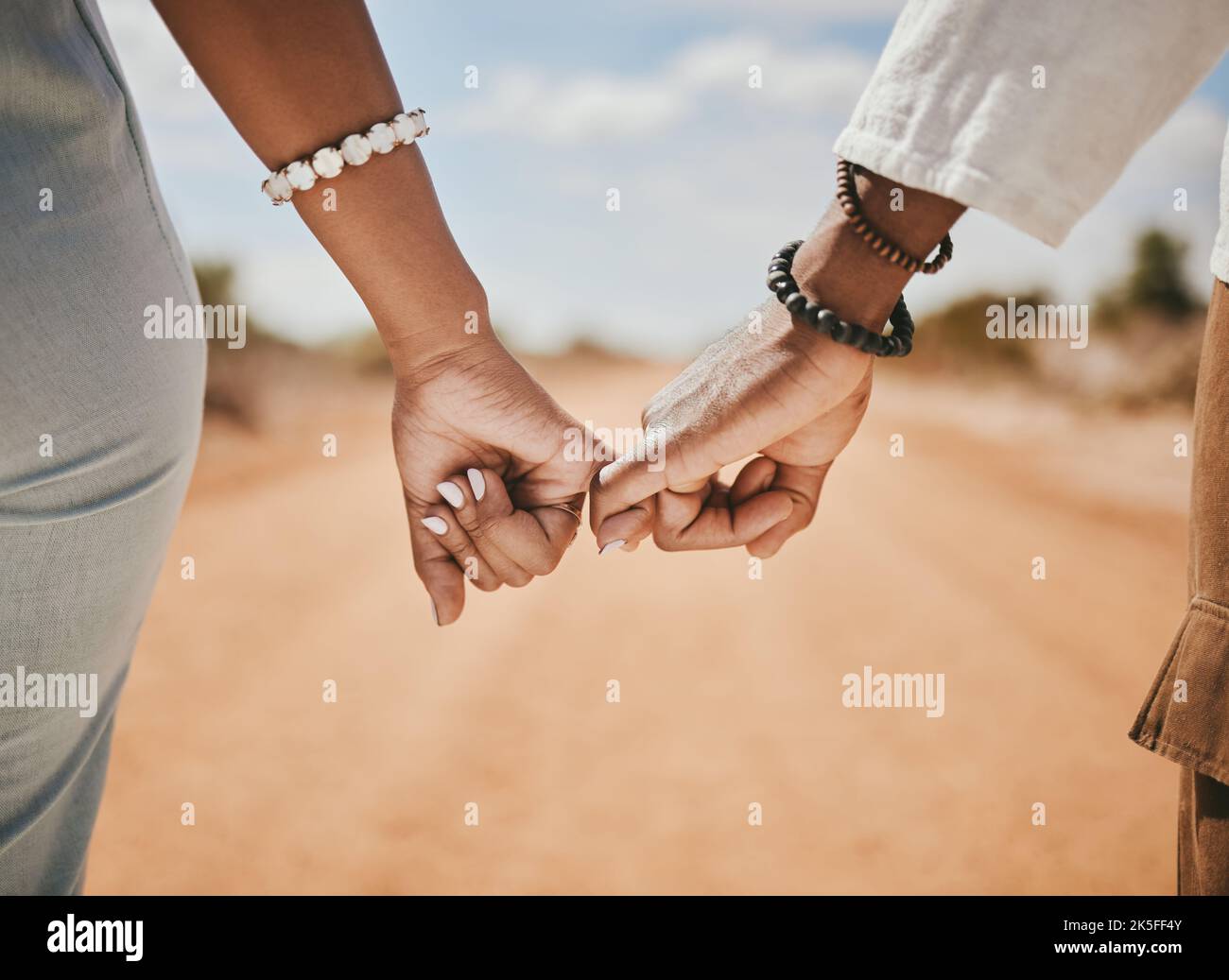 Couple marchant, promettre et accrocher les doigts pour le soutien, la confiance et l'amour dans la nature en plein air. Gros plan homme, femme et de connecter les mains pinky dans l'espoir, le respect Banque D'Images