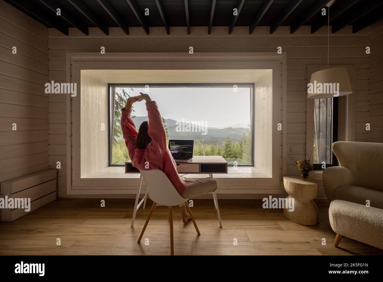 Femme travaille sur ordinateur portable à distance dans la maison sur la nature Banque D'Images