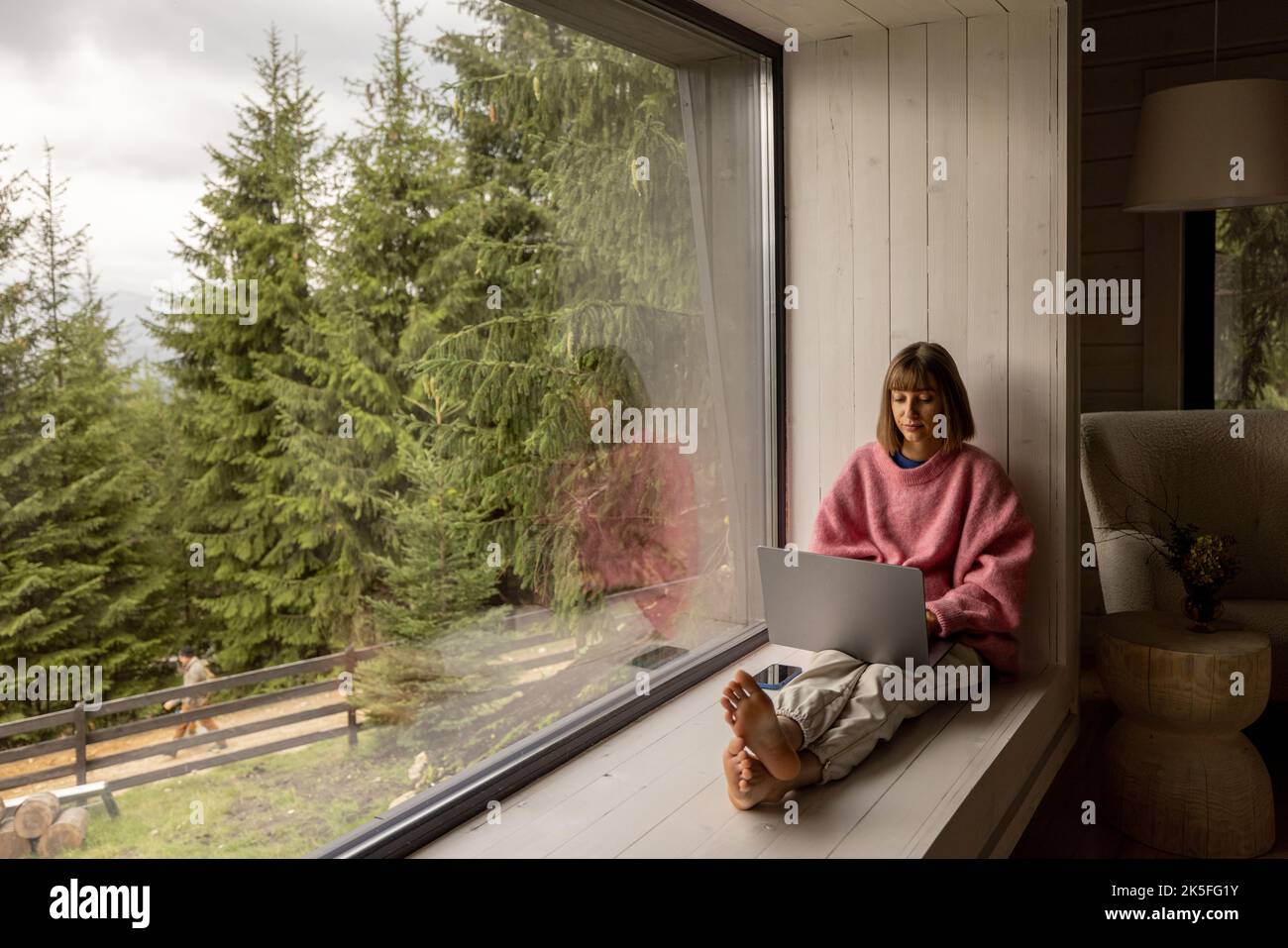 Femme travaille sur ordinateur portable à la maison dans les montagnes Banque D'Images