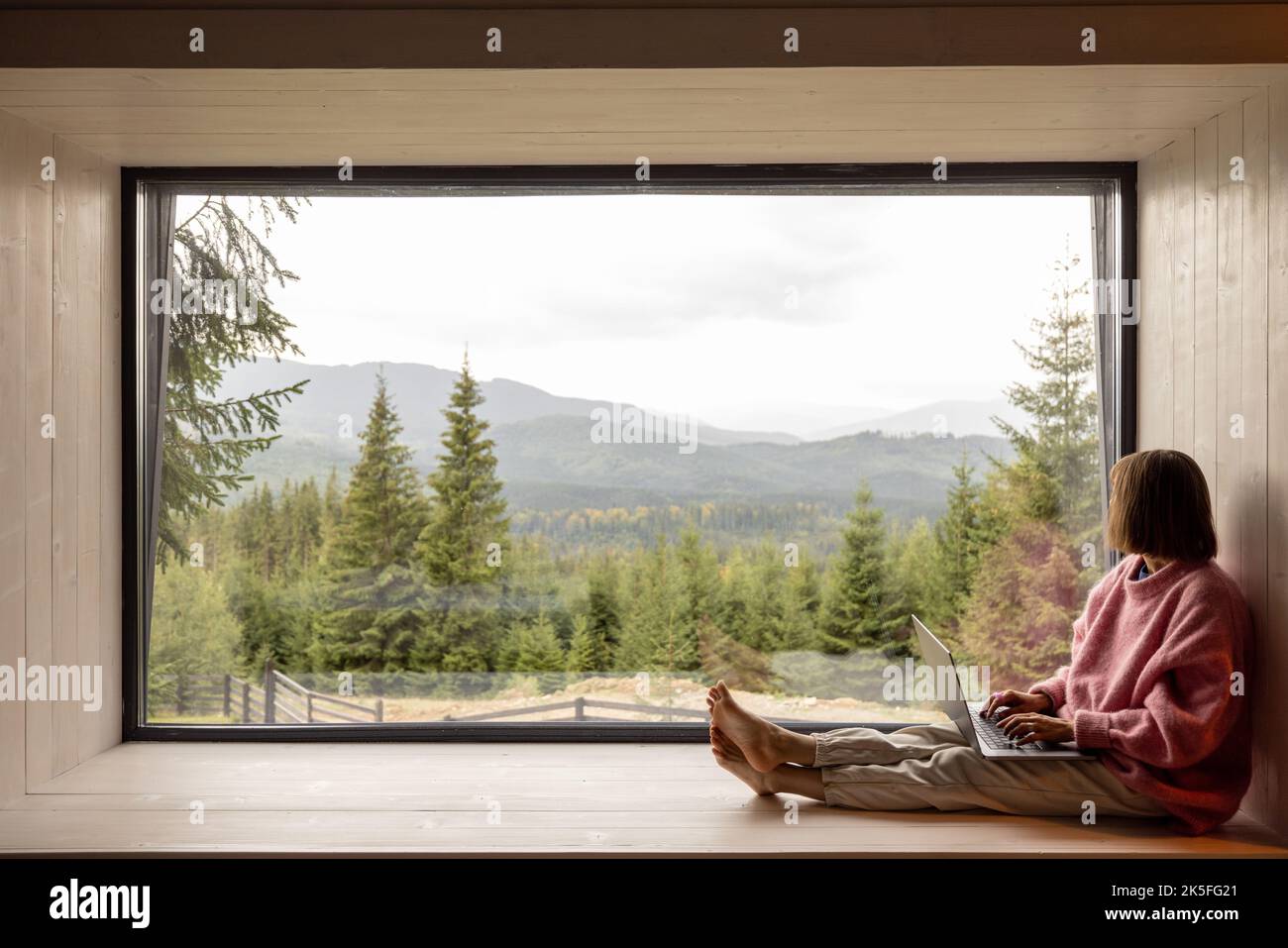 Femme travaille sur ordinateur portable à la maison dans les montagnes Banque D'Images