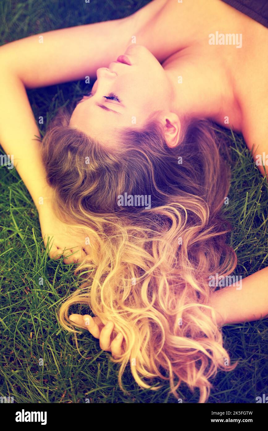 Nostalgie dans le parc. Une jeune fille attrayante couché sur l'herbe à l'extérieur. Banque D'Images