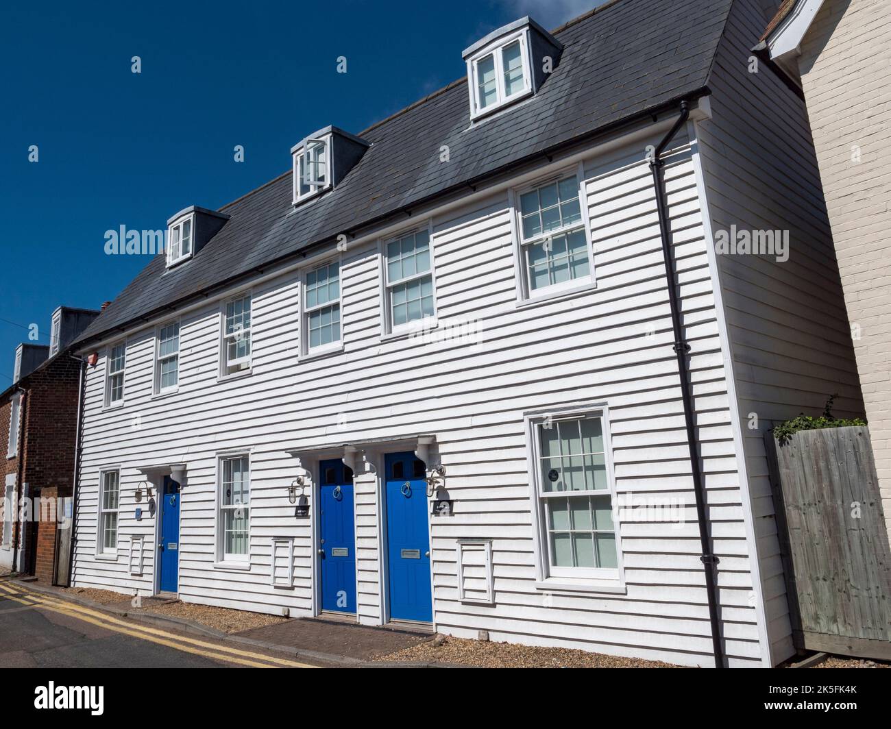 Chalets à façade en bois blanc sur Island Wall, Whitstable, Kent, Royaume-Uni. Banque D'Images