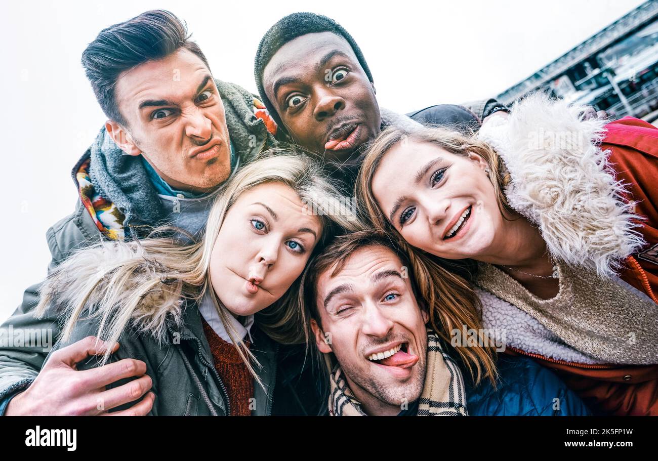 Les meilleurs amis multiraciaux prennent le selfie en plein air sur les vêtements d'hiver d'automne - concept de jeunesse heureux avec les gens du millénaire s'amuser ensemble - Multicultur Banque D'Images