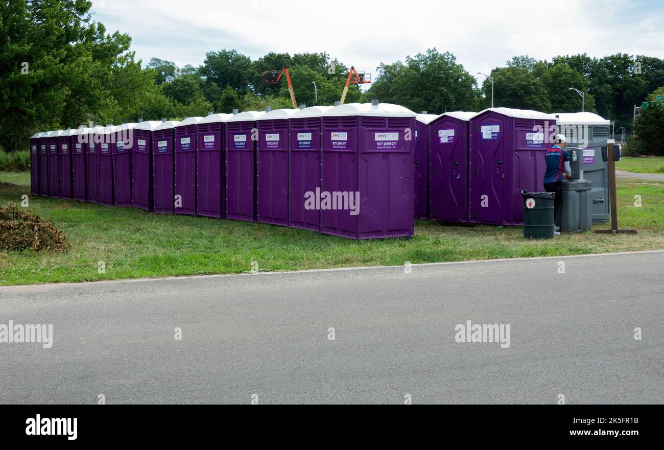 32 toilettes portatives violettes dans le parc Corona de Flushing Meadows le week-end des courses annuelles de bateaux-dragons. À Queens, New York. Banque D'Images