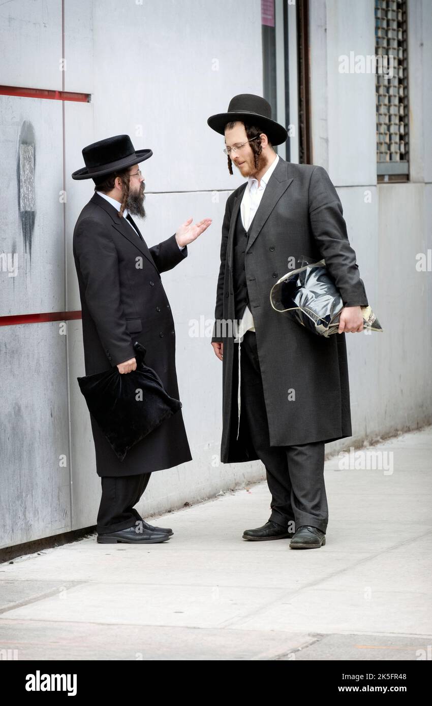 Deux juifs hassidiques, probablement du groupe Satmar, ont une conversation animée à un coin de rue à Williamsburg, Brooklyn, New York. Banque D'Images