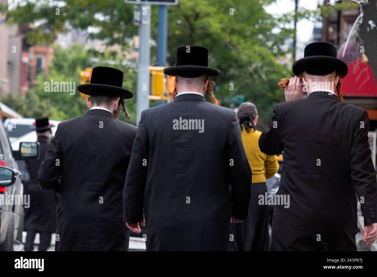 3 hommes hassidiques non identifiables avec peyus et vêtus de noir. Sur Lee Avenue à Williamsburg, Brooklyn, New York. Banque D'Images