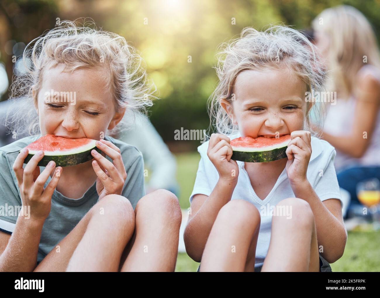 Happy, pique-nique et pastèque avec les enfants dans le parc avec la famille pour l'été, bien-être et détente. La santé, la nature et le printemps avec les enfants manger des fruits dedans Banque D'Images