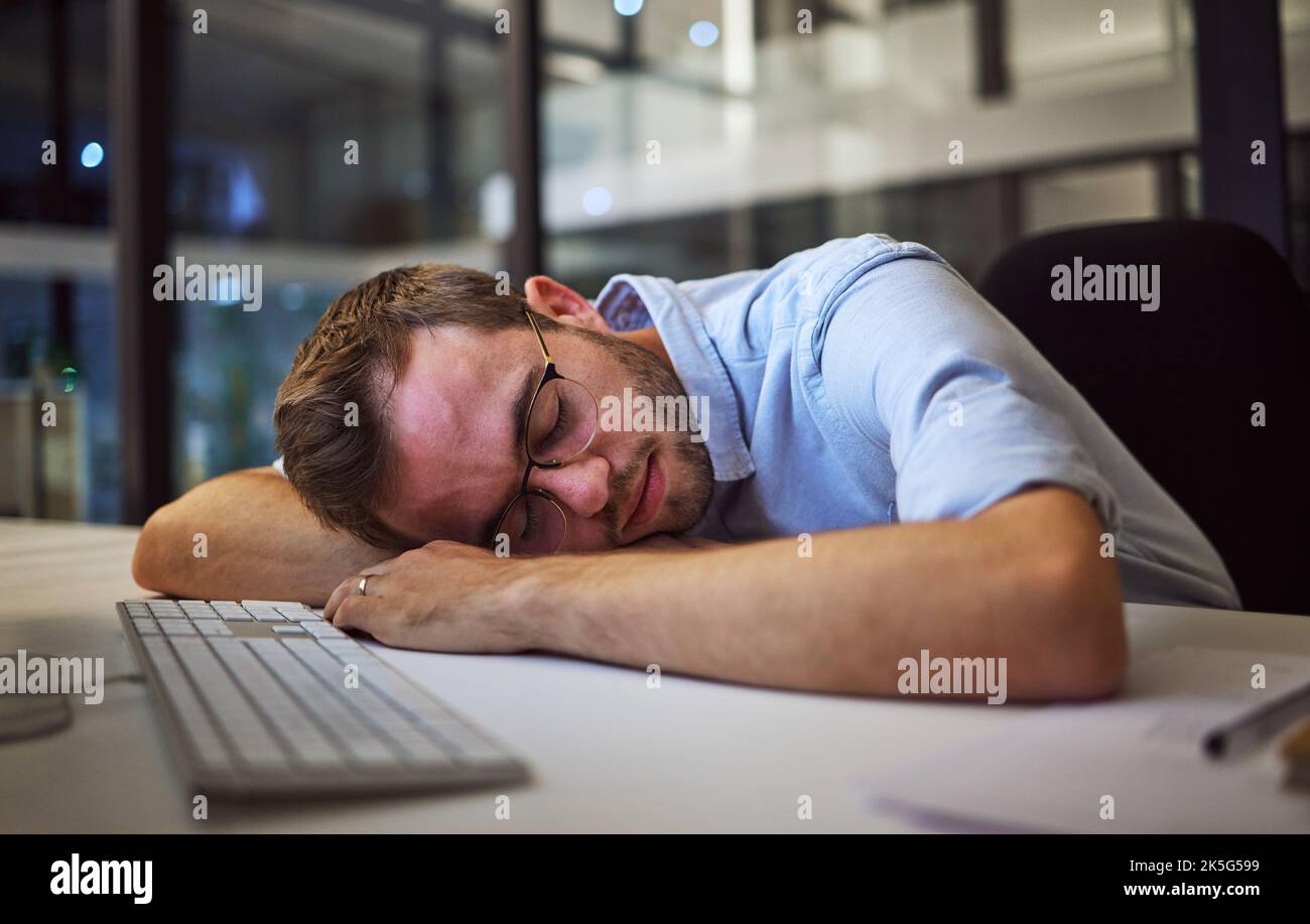 Nuit de sommeil, business burnout et homme d'affaires dormant à son bureau dans son bureau sombre au travail. Employé, employé ou responsable d'entreprise fatigué avec stress Banque D'Images