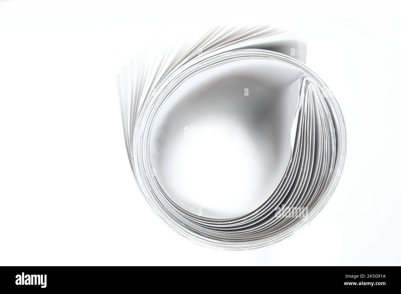 Journal enroulé sur fond blanc, gros plan avec focus sélectif.lecture, flux de nouvelles, concept d'information. Banque D'Images