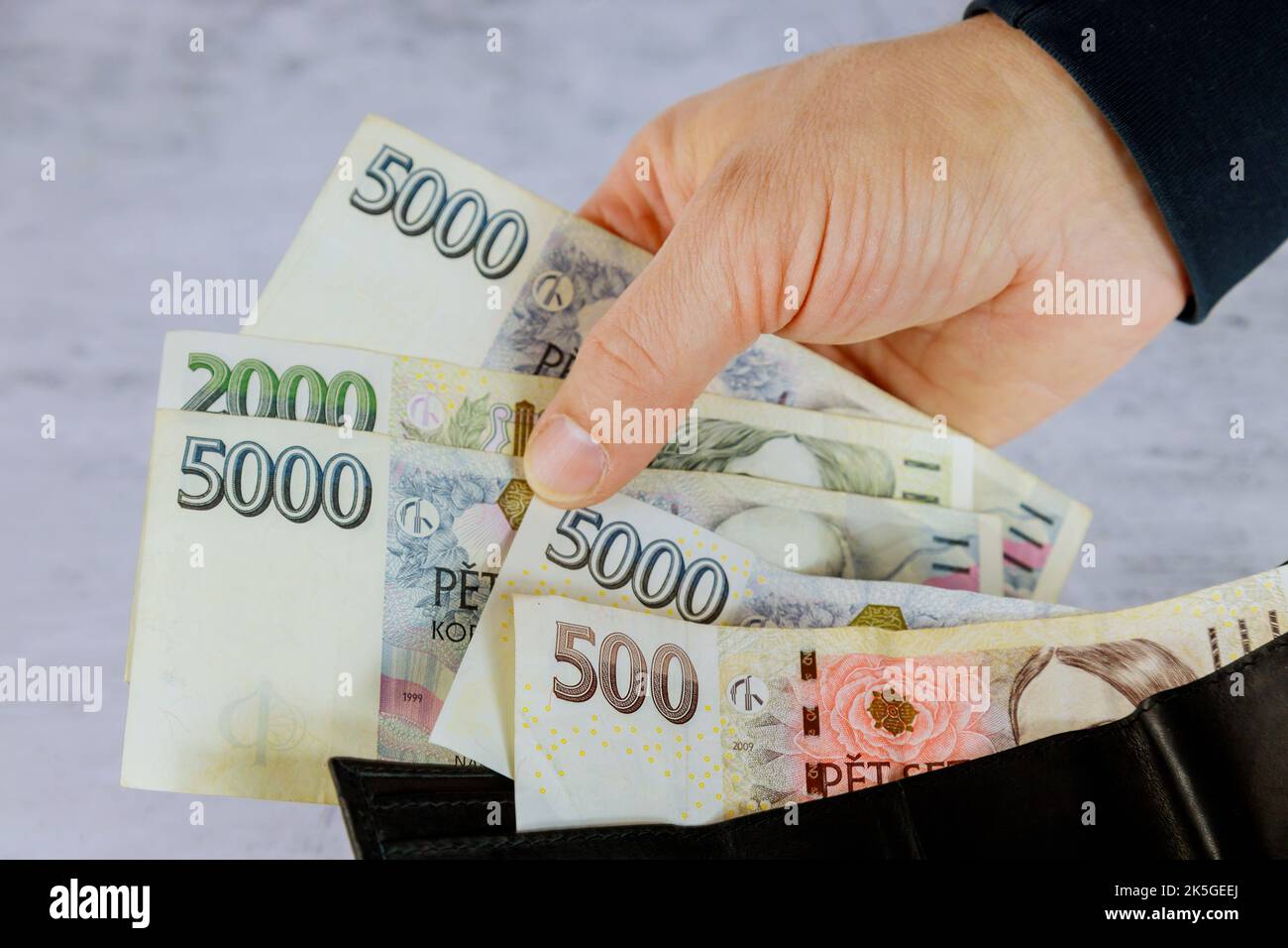 Compte de la couronne tchèque CZK dans le portefeuille de l'homme détenant des billets de la couronne tchèque Banque D'Images