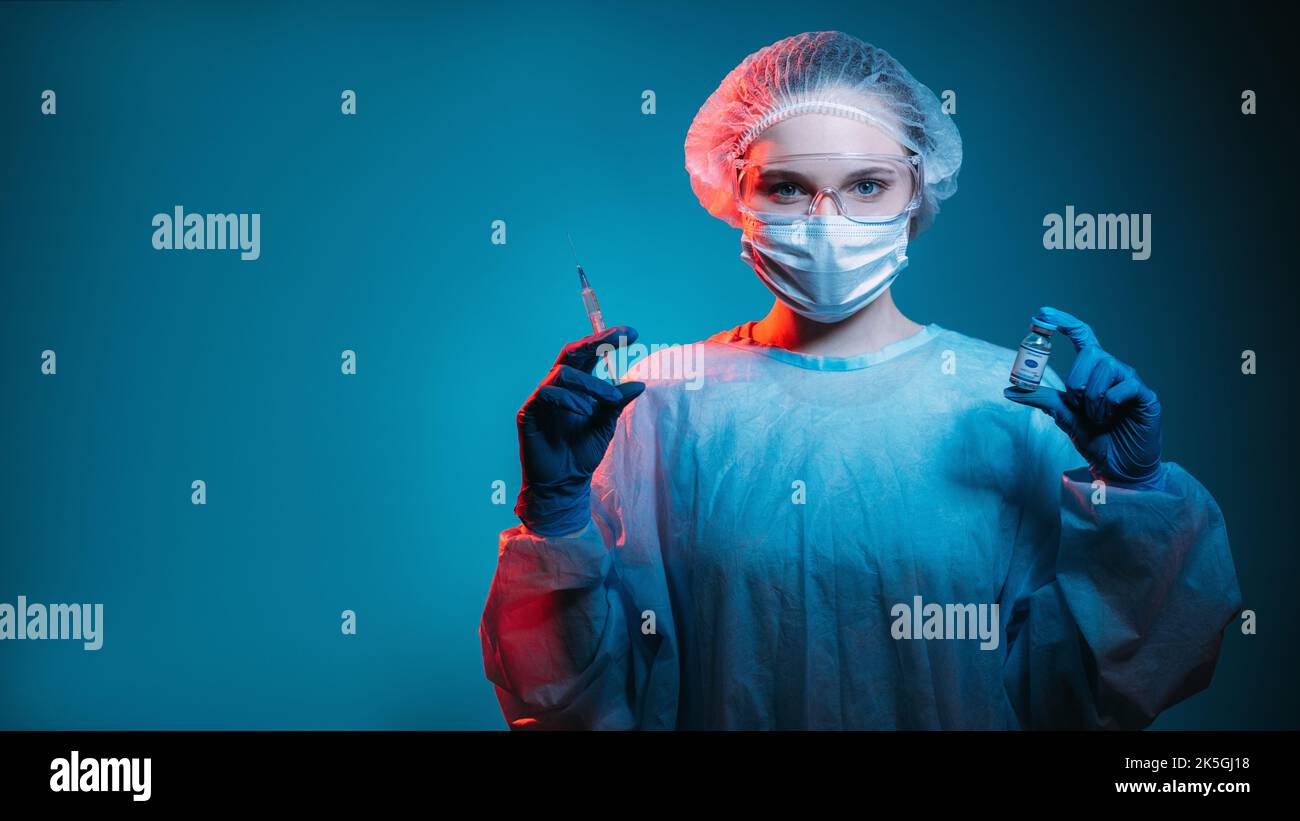 Vaccin Covid-19. Vaccin contre la grippe. Immunisation en cas de pandémie. Portrait d'une femme médecin confiante en epi masque masque lunettes gants avec seringue de flacon de dose en rouge n Banque D'Images