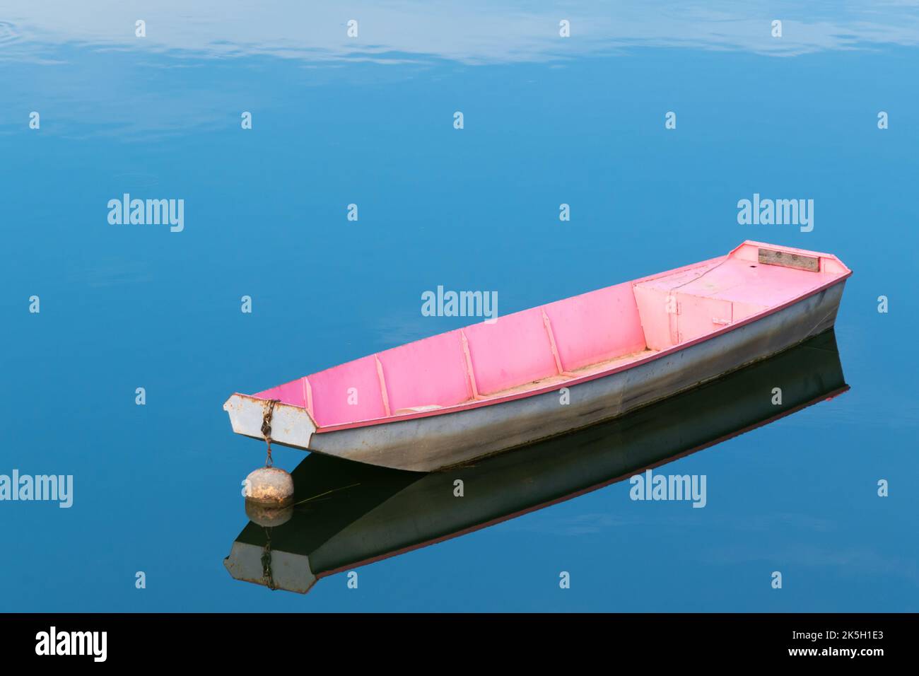 Bateau amarré dans l'eau isolée, réflexion dans l'eau fixe Banque D'Images