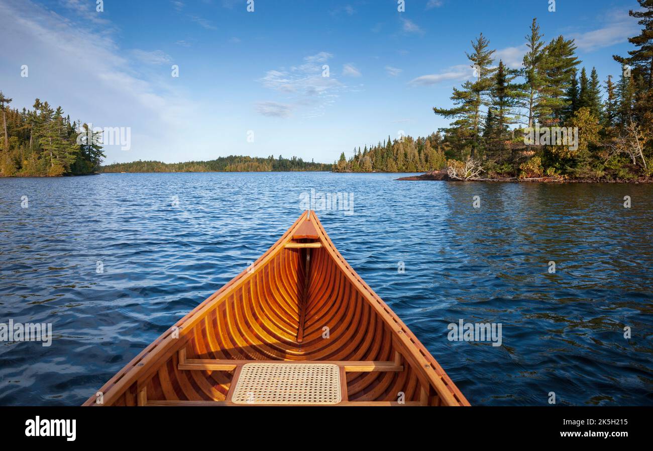 Canoë en bois sur un lac bleu Boundary Waters avec des îles le matin de l'automne Banque D'Images