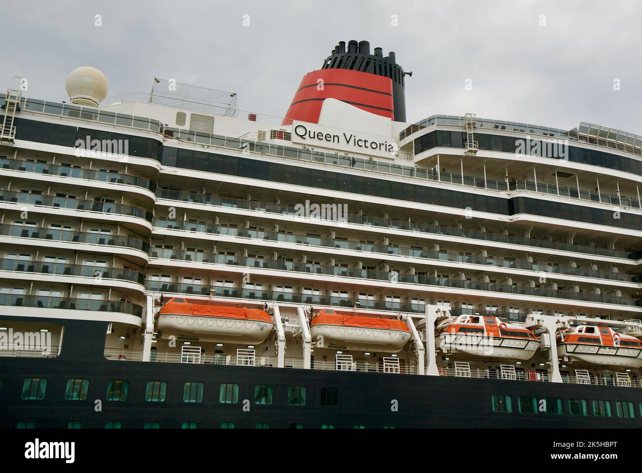 Vue latérale du bateau de croisière Cunard Queen Victoria, donnant sur la plaque de nom, les balcons et la cheminée. Banque D'Images