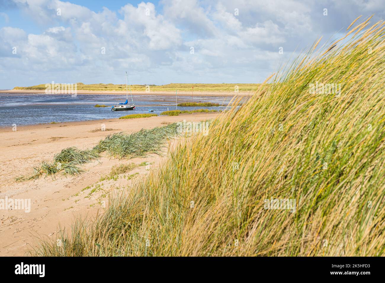 Un seul yacht amarré hors de la plage à Hightown près de Liverpool vu en face de l'herbe des dunes en octobre 2022. Banque D'Images