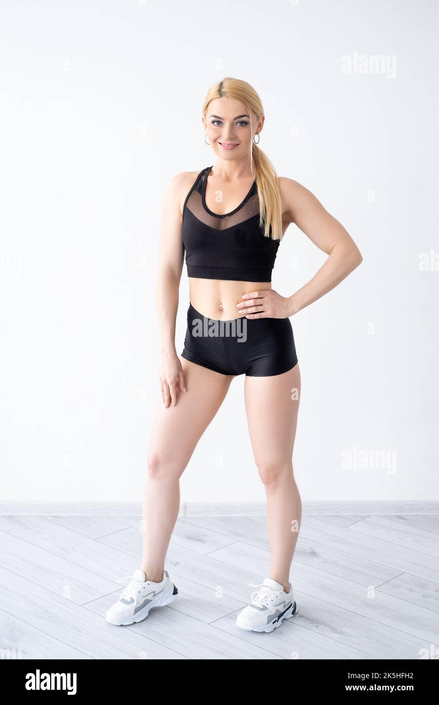 Femme athlétique. Poser le corps. Le sport et un mode de vie sain. Short et haut courts de sport noirs Banque D'Images Femme athlétique. Poser le corps. Le sport et un mode de vie sain. Short et haut courts de sport noirs Banque D'Images