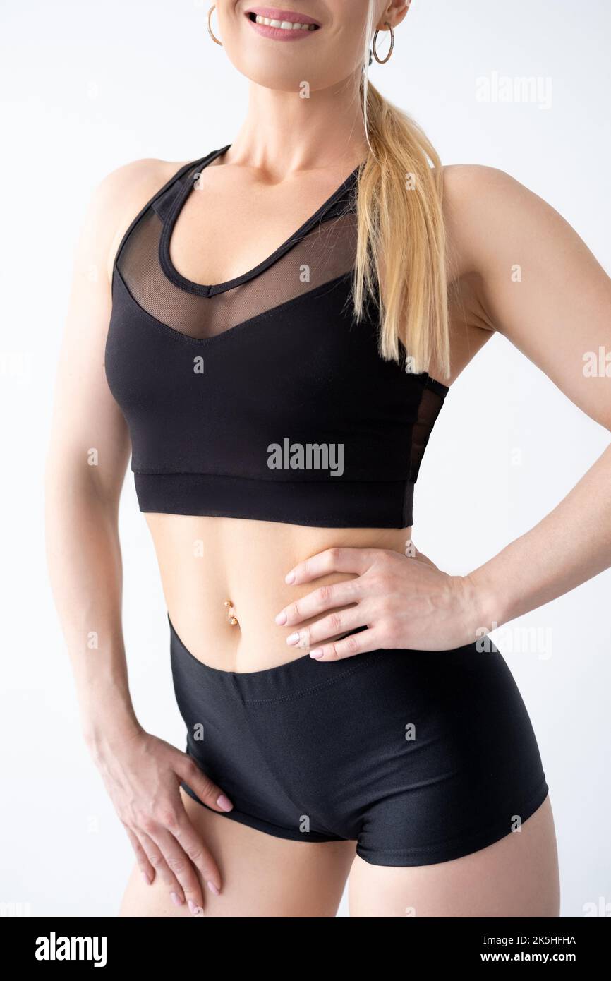 Femme athlétique. Poser le corps. Le sport et un mode de vie sain. Short et haut courts de sport noirs Banque D'Images Femme athlétique. Poser le corps. Le sport et un mode de vie sain. Short et haut courts de sport noirs Banque D'Images
