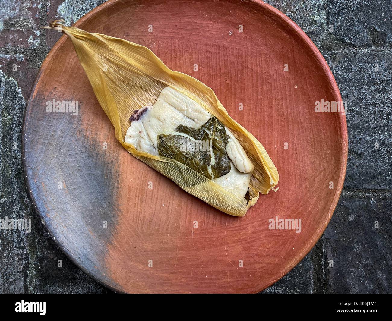 Un Oaxacan Tamal sur une assiette faite avec masa et hierba santa Banque D'Images