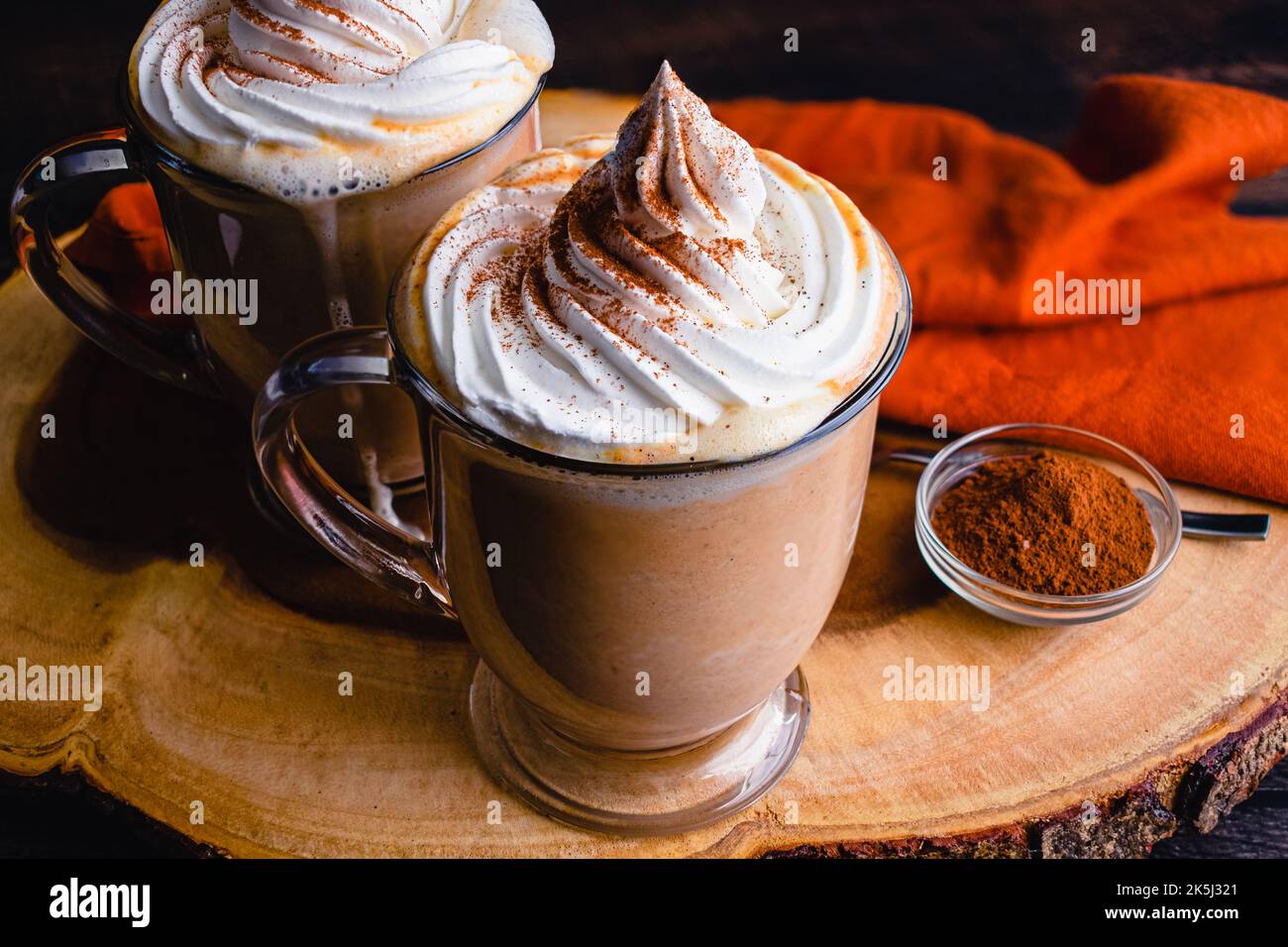 Chocolat chaud aux épices de citrouille recouvert de crème fouettée : mugs de chocolat chaud nappés de crème chantilly et d'épices de citrouille Banque D'Images