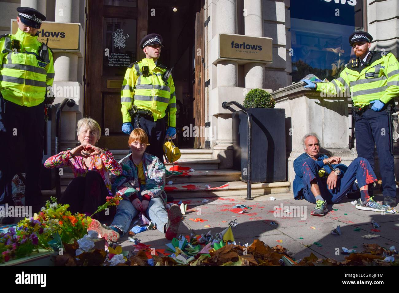 Londres, Royaume-Uni. 8th octobre 2022. Les activistes de la rébellion animale de la garde de police qui ont éclaboussé l'équipement de chasse stockent les Farlows avec de la peinture rouge. Le groupe des droits des animaux a défilé dans le centre de Londres pour exiger la fin de toutes les formes d'exploitation animale et un avenir fondé sur les plantes. Credit: Vuk Valcic/Alamy Live News Banque D'Images