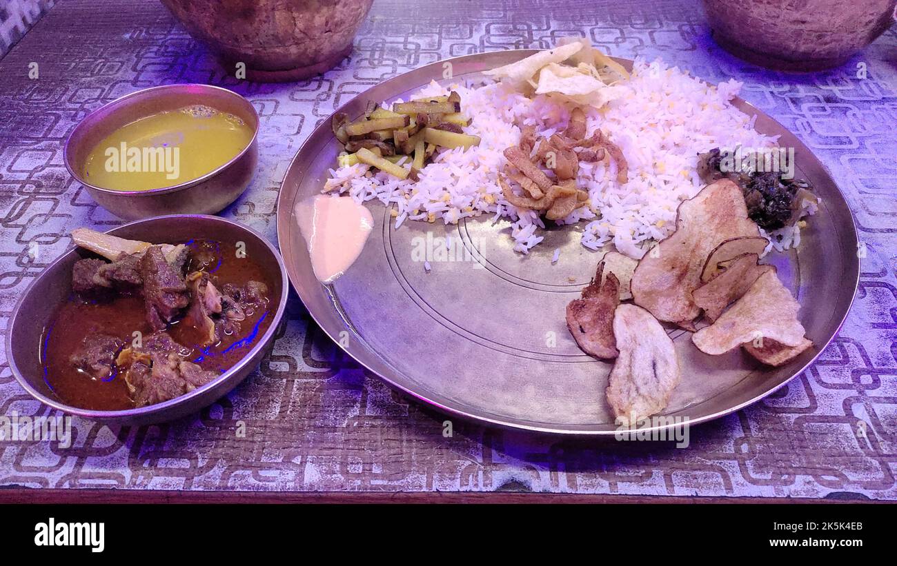 thali traditionnel népalais servi sur une assiette en laiton avec du riz, du curry de viande, des lentilles et d'autres plats d'accompagnement. aliments de base pour la culture népalaise. Banque D'Images