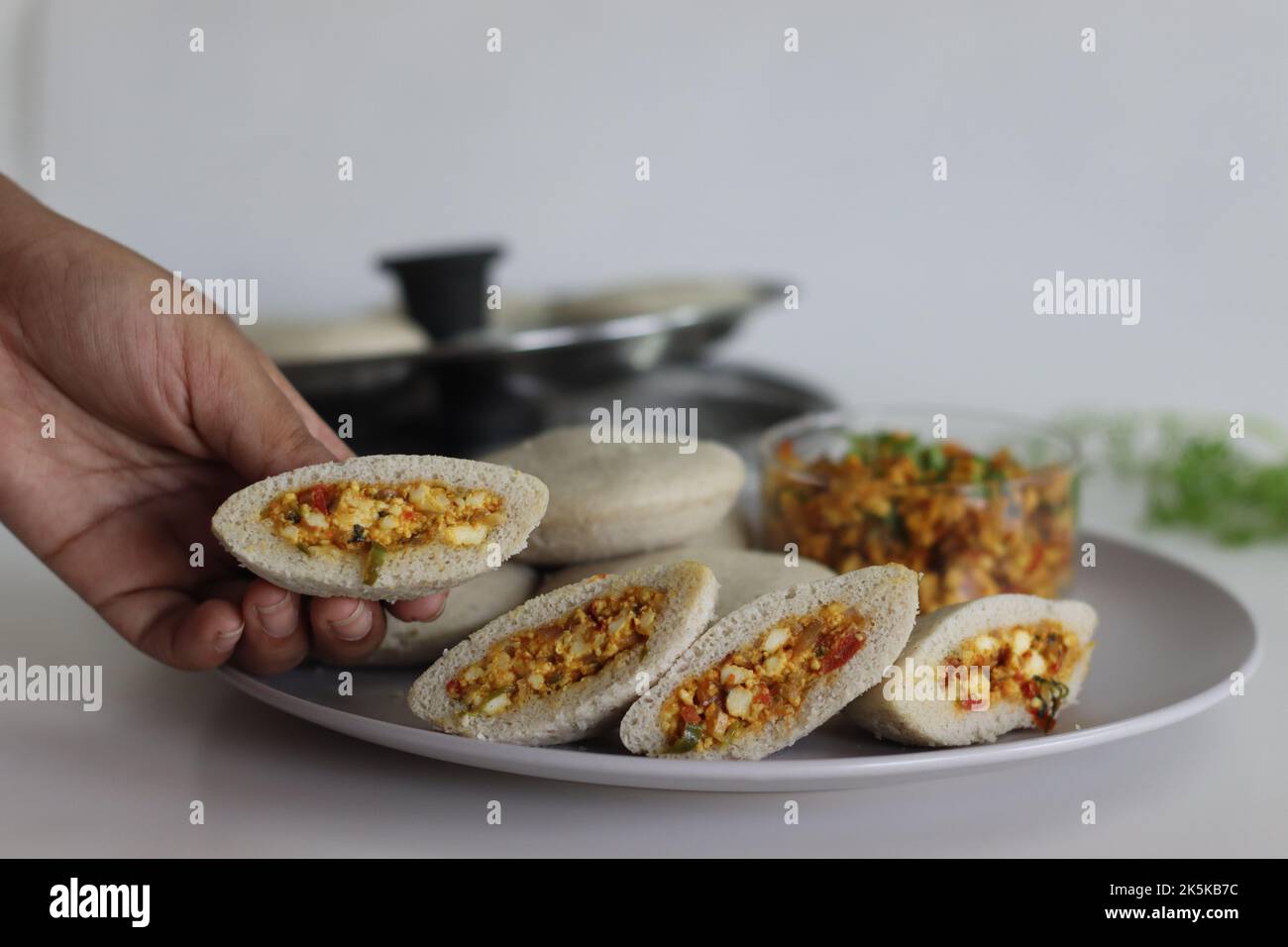 Paneer farci kodo millet sans rien. Gâteaux salés cuits à la vapeur faits de millésimes de kodo et de farine de lentilles farcies avec une patty faite de fromage cottage brouillés avec Banque D'Images