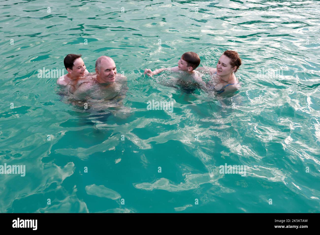 Baignade en famille dans la piscine ouverte en été Banque D'Images